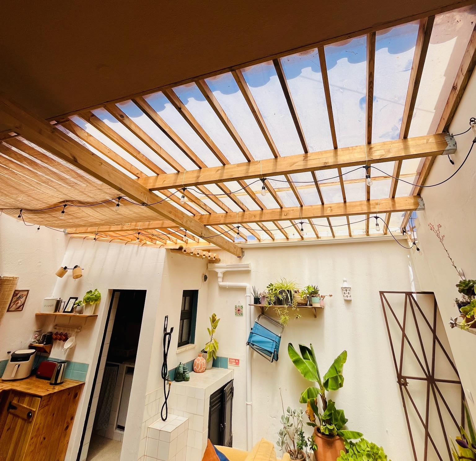 Handmade timber roof spanning a bright planted courtyard